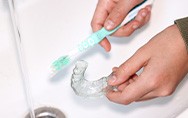 Invisalign patient in Conway cleaning their aligners