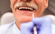 a man smiling and laying back in a dental chair