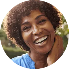 Older woman in blue blouse smiling outdoors