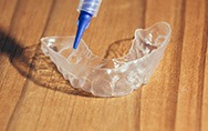 a teeth whitening tray with a syringe of gel